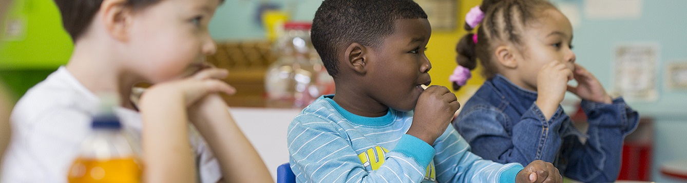 Preschool children eating a healthy snack at school.