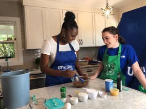 Zyreshia Jackson and youth with kitchen ingredients and utensils