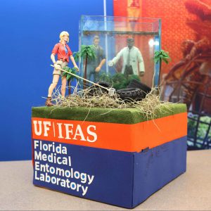 Florida Medial Entomology Lab's Shoebox Parade Float featuring live mosquito larvae. Text reads UF/IFAS Florida Medical Entomology Labratory.