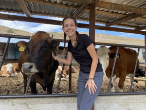 Student posing with cows