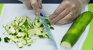 Cutting up zucchini on a cutting board.