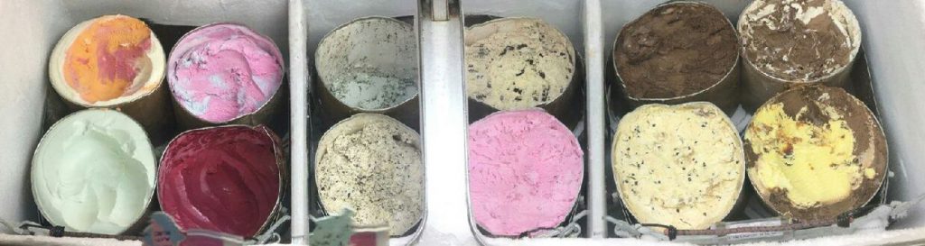 12 buckets of variety color ice cream in freezer