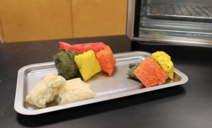 orange, yellow, green and regularly-colored bread loaves on a tray