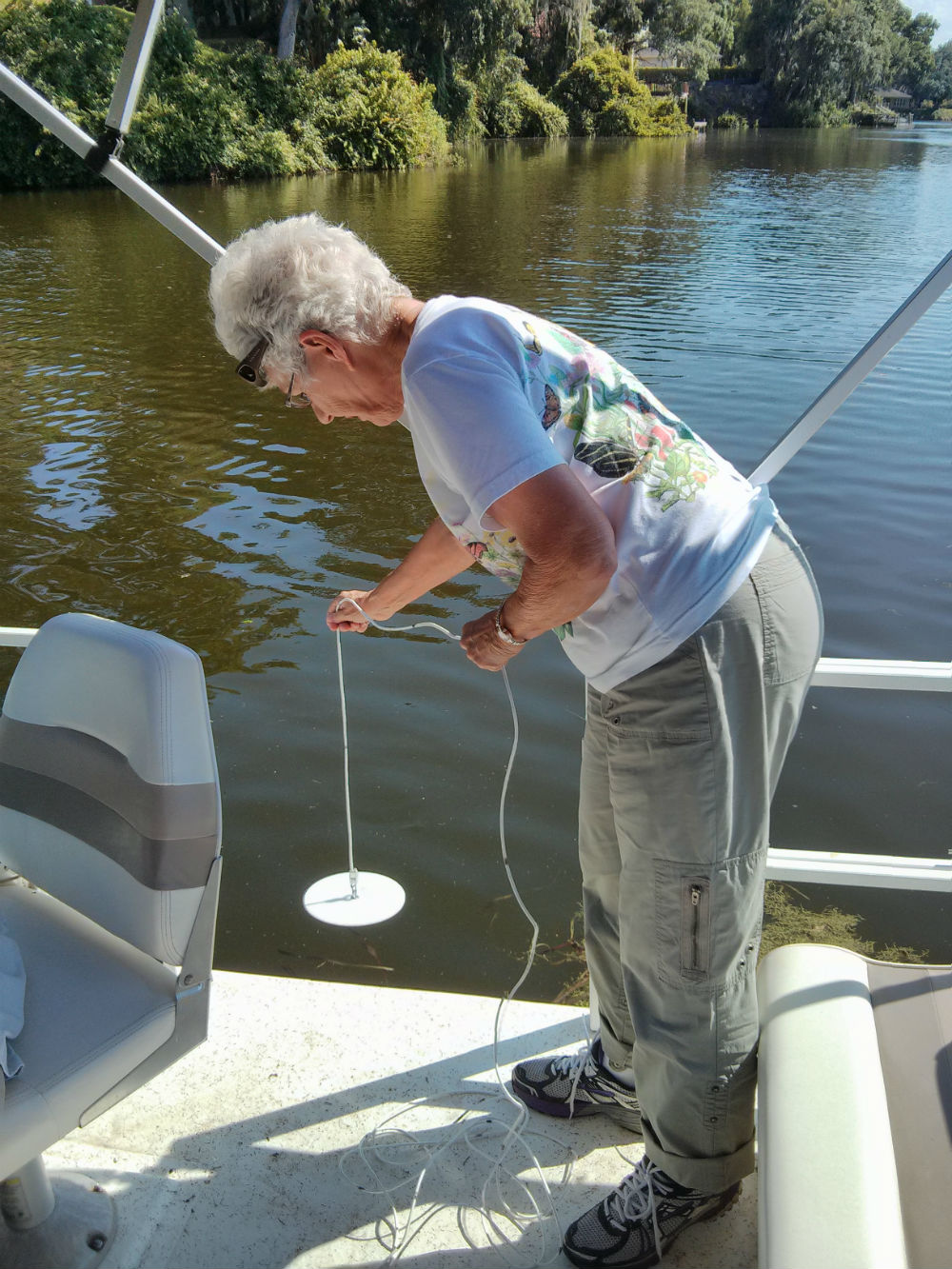 A lakewatch volunteer in Lakeland, FL  demonstrates how to take a secchi disk sample.