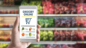A user holds a smartphone with a faux "Grocery Online" shopping list app. [CREDIT: pixabay.com, Ilan Shatz]