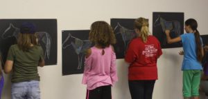 Youth coloring the muscle groups on a horse picture