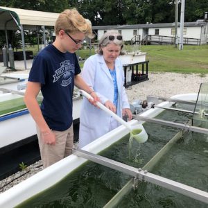 scientist and student at algal pond as part of the soil and water sciences department's open door policy