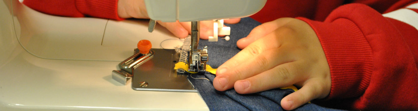 close-up of child's hands using a sewing machine