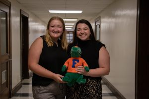 Female students holding gator award