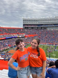 Two girls in orange Florida Gator shirts at a Florida football game