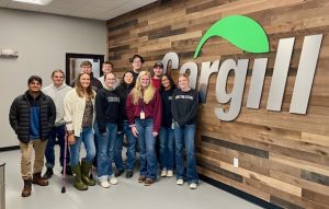 Group of interns posing in front of Cargill signage in their main lobby. 