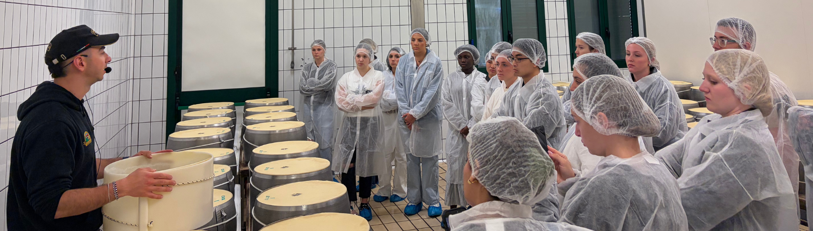 Students learn about cheese production at a factory in Italy.