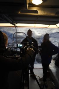 News interview on the back deck of a boat at dawn.
