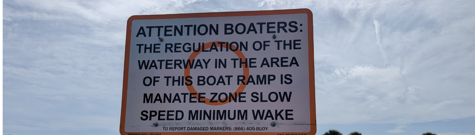 Sign at boat ramp that says attention boaters the regulation of the waterway in the area of this boat ramp is manatee zone slow speed minimum wake