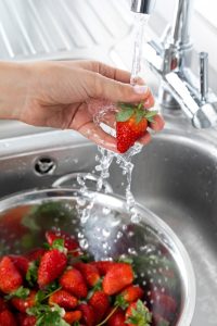 Washing strawberries in a kitchen sink