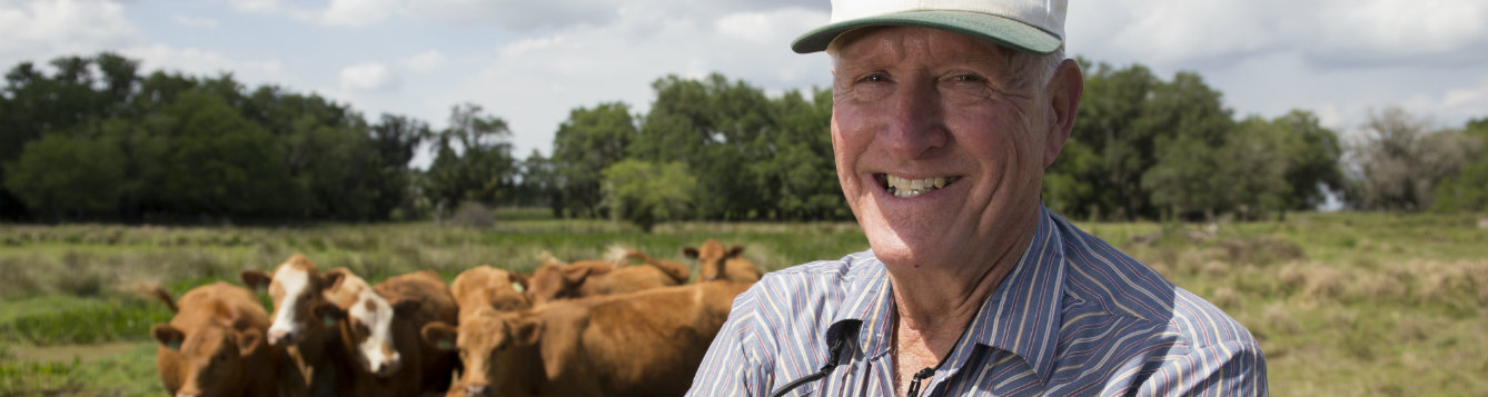 Farmer smiling in front of his cattle