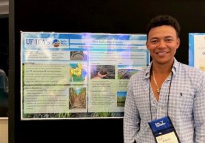 Ortez standing in front of the poster he presented on soil and water health.