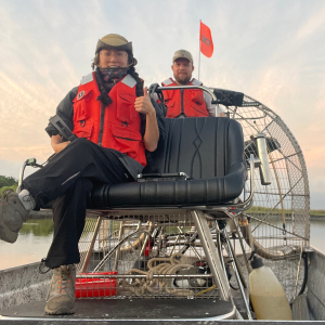 Student intern on airboat with researcher.