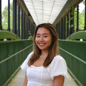 Woman standing in front of bridge. 