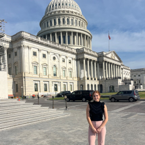 Woman in front of Capitol building.