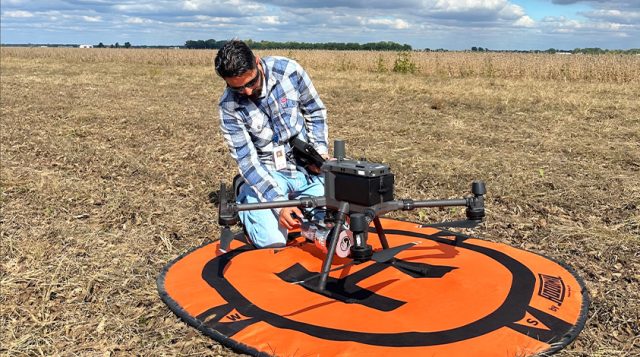 An intern working in a field with satellite guided technology