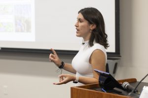 A female student speaking on her extension internship experience at a banquet.
