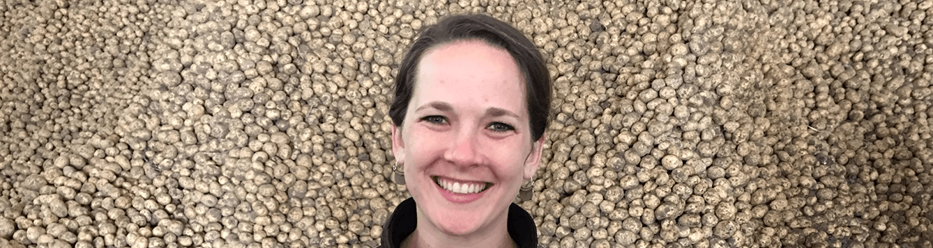 CALS alumna Kendra Levine in front of a background of harvested potatoes