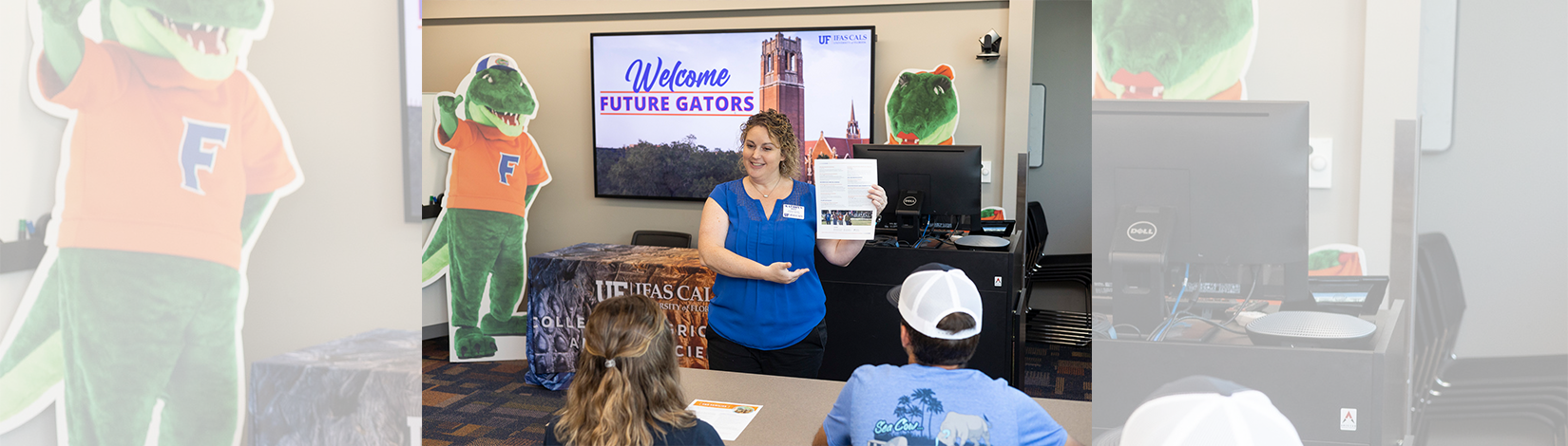An adviser showing students a paper handout.
