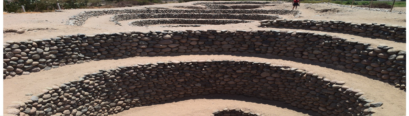 Spiral stone well in Peru with a winding ramp leading down to an underground water channel.