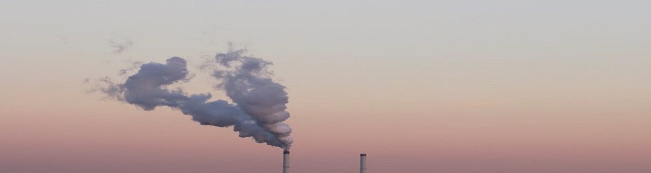 Industrial towers releasing smoke into the air.