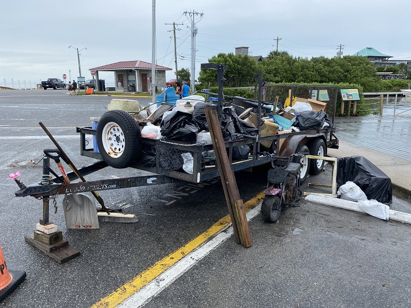 a pile of muddy, wet trash loaded onto a utility trailer