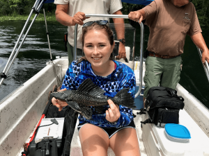 Intern Kelly Colvin holding a suckermouth catfish 