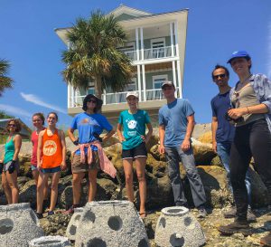 Volunteers pose by reef balls they helped install