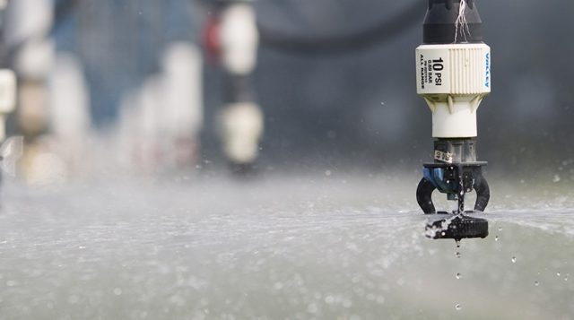 Sprinkler heads of a linear irrigation system irrigating crops at the North Florida Research and Education Center in Live Oak, Florida.