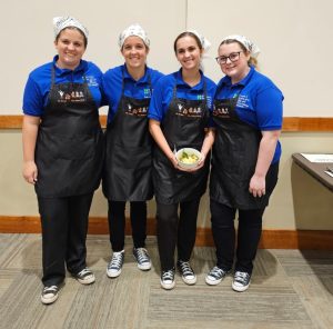 Four 4-H team members posing with food dish