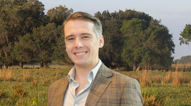 Nathan Palardy in front of agricultural pasture land