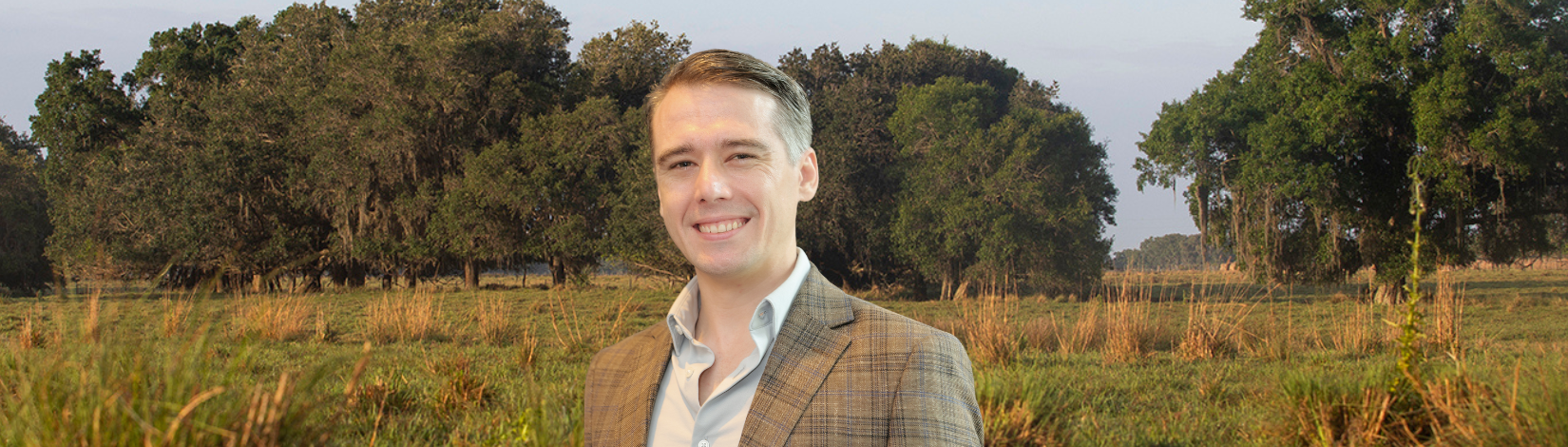 Nathan Palardy in front of agricultural pasture land