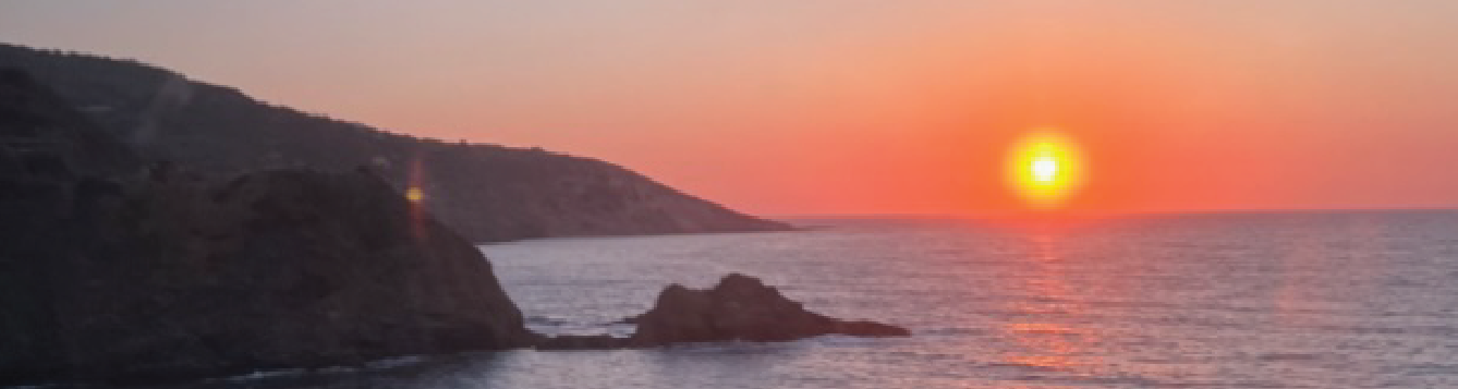 photo of sunset on water with island silhouetted on left side