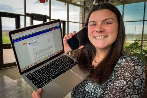 Ashtyn talking on the phone and holding a laptop up to the camera, viruses | Food Science and Human Nutrition UF/IFAS