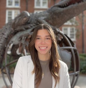 Taby stands outside in front of a gator statue