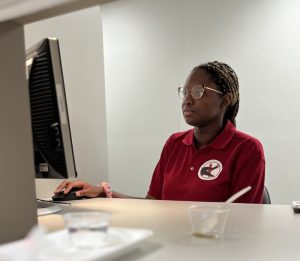 TOI student works on the computer with tasting cups in front of her, Taste x UF | Food Science and Human Nutrition UF/IFAS