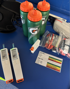 Water bottles and hydration materials sitting on a blue tablecloth, dietetics undergraduate student | Food Science and Human Nutrition UF/IFAS