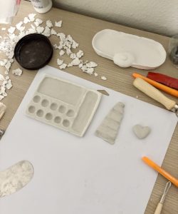 A table with molded clay and clay-shaping tools.