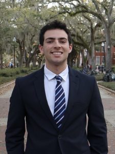 Zachary Howard wearing a suit and standing in front of trees | Food Science and Human Nutrition UF/IFAS