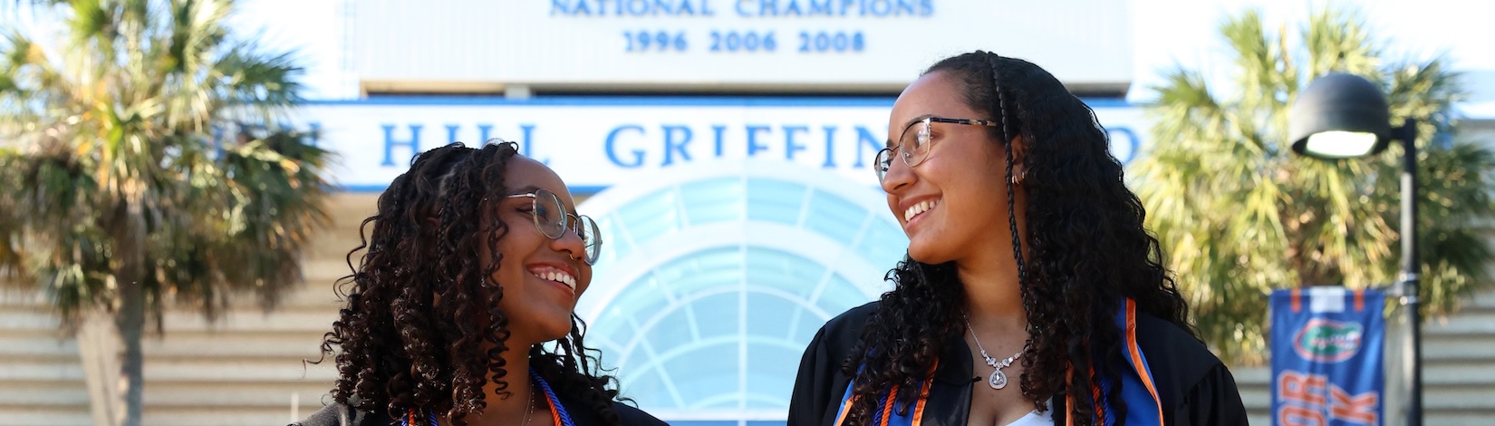 Rachel and a friend smiling at each other outside Griffin Stadium.