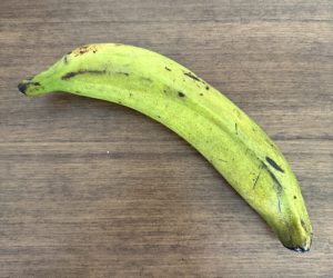 Green plantain on wooden table.