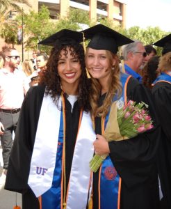 Evelyn and her friend wearing graduation robes and holding flowers, opportunity | Food Science and Human Nutrition UF/IFAS