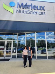 Rose and classmate in front of a large building.