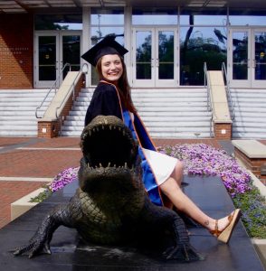 Emily in graduation robes sitting outside on a gator statue, celiac disease | | Food Science and Human Nutrition UF/IFAS