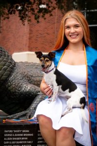 Genevieve sitting outside holding a small dog, mindful eating | Food Science and Human Nutrition UF/IFAS